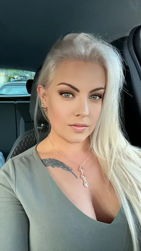 Selfie of Elise Muse with platinum hair and blue eyes in a grey top